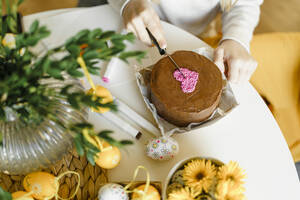 Hände eines Mädchens schneiden Osterkuchen auf dem Tisch zu Hause - VBUF00273