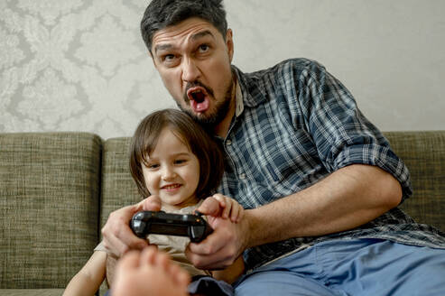Vater spielt Videospiel mit Sohn zu Hause - ANAF01034