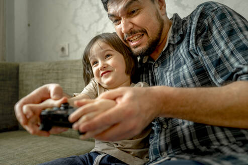 Vater und Sohn spielen zu Hause Videospiele - ANAF01035
