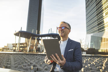 Geschäftsmann mit Tablet-PC an einem sonnigen Tag - JCCMF09458