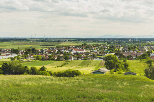Österreich, Niederösterreich, Prottes, Blick auf ein Dorf inmitten von grünen Sommerfeldern - AIF00780