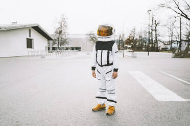 Boy in spacesuit standing on road - NDEF00347
