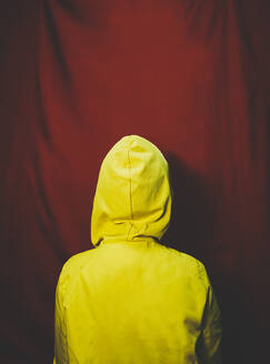 Frau mit gelbem Kapuzenpulli vor rotem Hintergrund - SVCF00358