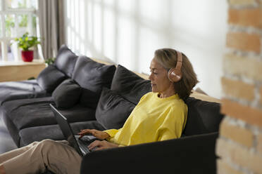 Freelancer working on laptop in living room - EBSF02796