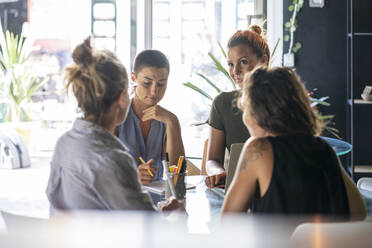 Businesswomen discussing plans at workplace - FBAF02081