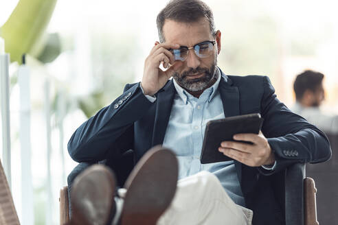 Geschäftsmann mit Brille und Tablet-PC am Arbeitsplatz - JSRF02432