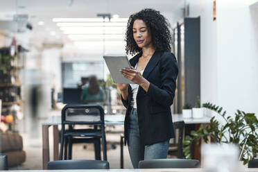 Businesswoman using tablet PC at office - JSRF02453