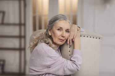 Ältere Frau sitzt auf einem Stuhl zu Hause - MDOF00645