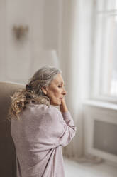 Contemplative senior woman with gray hair at home - MDOF00648