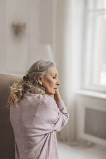 Nachdenkliche ältere Frau mit grauem Haar zu Hause - MDOF00648
