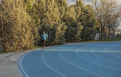 Athlete running on sports track - JCCMF09482