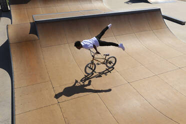 Man practicing stunts on BMX bike at skatepark - SYEF00225