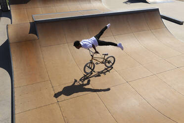 Mann übt Stunts auf BMX-Rad im Skatepark - SYEF00225
