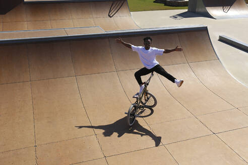 Junger Mann balanciert auf BMX-Rad im Skatepark - SYEF00226