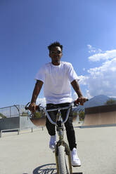 Mann fährt BMX-Rad an einem sonnigen Tag im Skatepark - SYEF00232