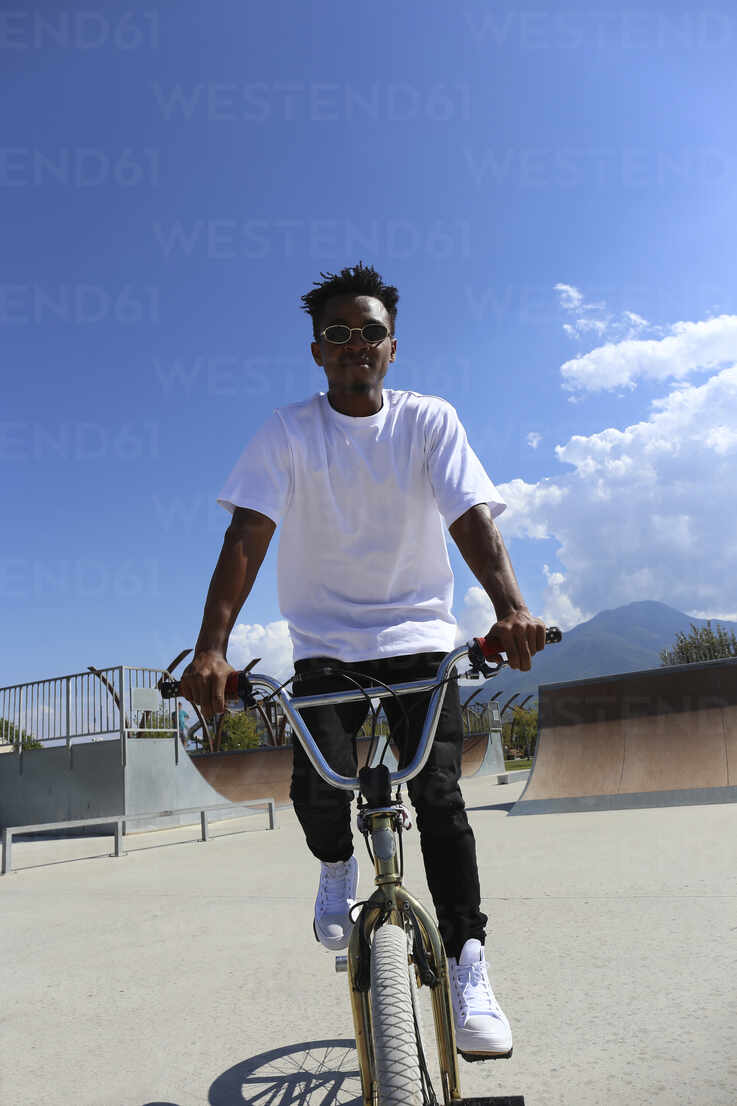 Free Photo  Young man riding on a bmx bicycle in skatepark