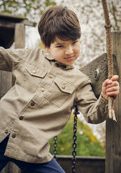 Boy holding plant stick at park - PWF00785