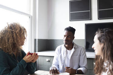 Businesswoman discussing plans with colleagues in office - AMWF01140