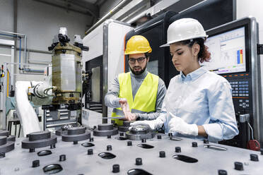 Engineers wearing hardhats working in factory - AAZF00119