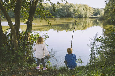 Boy playing with girl near lake - NDEF00365