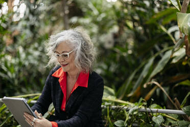 Geschäftsfrau benutzt Tablet-PC im Garten - JCCMF09501