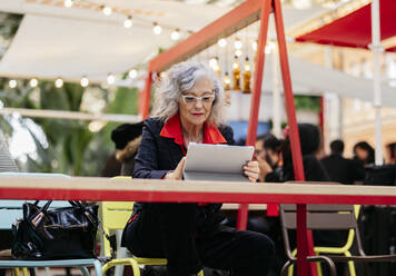 Ältere Geschäftsfrau mit Tablet-PC in einem Café - JCCMF09514