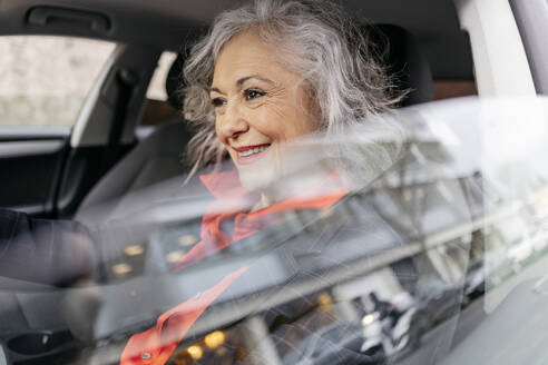 Smiling mature businesswoman driving car - JCCMF09570