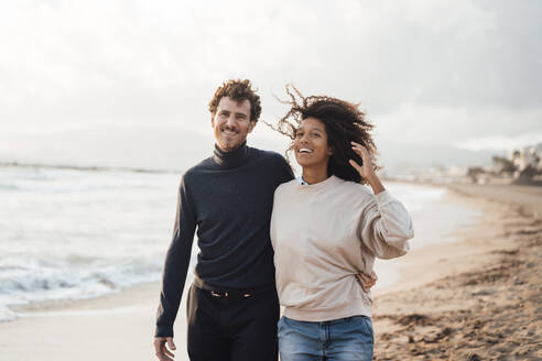 Glücklicher Mann und Frau gehen zusammen am Strand spazieren - JOSEF17255