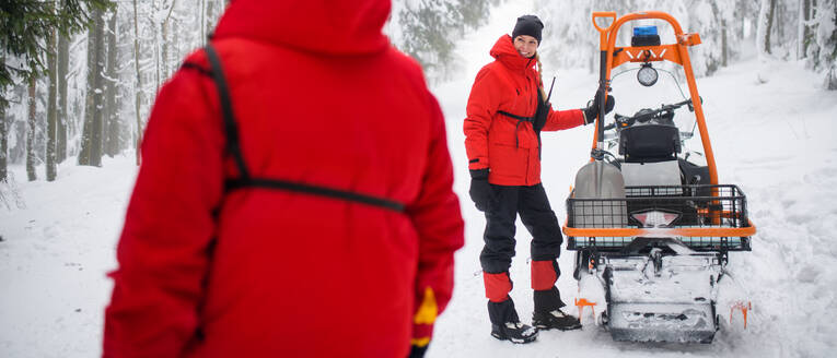 Rettungssanitäterin vom Bergrettungsdienst führt einen Einsatz im Freien im Winter im Wald durch. - HPIF06071