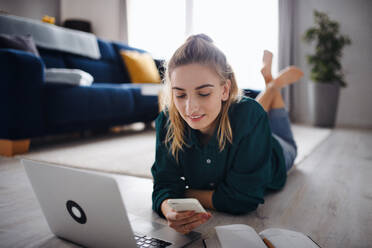 A young woman student with laptop and smartphone at home, home office and learning. - HPIF06152