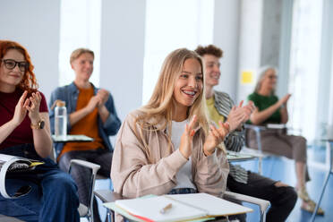 A portrait of group of university students sitting in classroom indoors, studying - HPIF06162