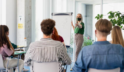 Universitätsstudenten mit einem Lehrer, der in einem Gebäude studiert, Coronavirus und das Konzept 