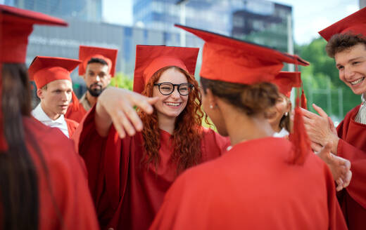 Fröhliche Studenten, die im Freien feiern und sich umarmen, ein Konzept für die Abschlussfeier. - HPIF06245
