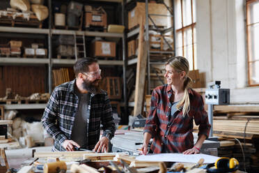 Two carpenters a man and a woman talking about design of products. Small business concept. - HPIF06428