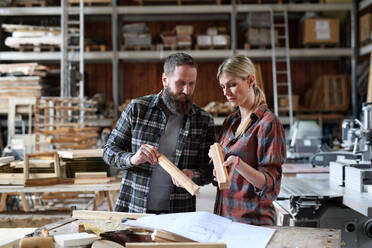 Two carpenters a man and a woman talking about design of products. Small business concept. - HPIF06432