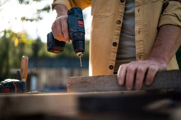 Eine Nahaufnahme von Handwerker Schreiner arbeiten in Schreinerei diy Werkstatt im Freien mit Bohrer. - HPIF06483