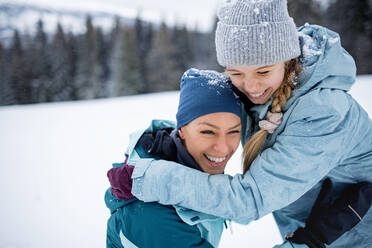 Mutter mit kleiner Tochter hat Spaß im Freien in der winterlichen Natur, Tatra-Gebirge Slowakei. - HPIF06561