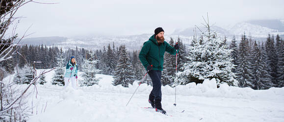 Aktives reifes Paar beim Skilanglauf im Freien in der winterlichen Natur, Tatra-Gebirge Slowakei. - HPIF06583