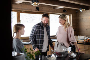 Happy family with small daughter cooking indoors, winter holiday in private apartment. - HPIF06596