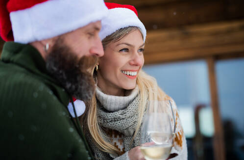 Glückliches reifes Paar trinkt Wein auf der Terrasse im Freien im Winter Natur, Urlaub zur Weihnachtszeit. - HPIF06647
