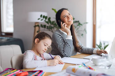 Mutter mit Schulmädchen drinnen zu Hause, Fernstudium und Home-Office-Konzept. - HPIF06649