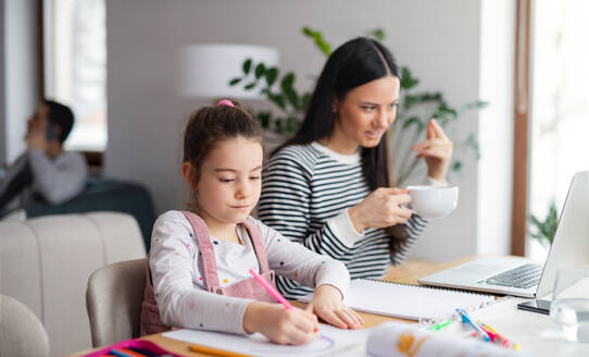 Mutter mit Schulmädchen drinnen zu Hause, Fernstudium und Home-Office-Konzept. - HPIF06651