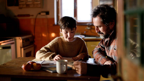 Ein armer, reifer Vater und seine kleine Tochter lernen zu Hause, ein Konzept der Armut. - HPIF06817