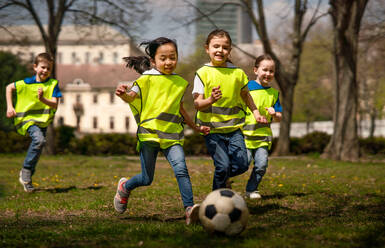 Glückliche kleine Kinder spielen Fußball im Freien im Stadtpark, Lerngruppe Bildungskonzept. - HPIF06880