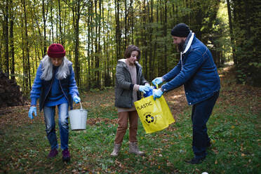 Eine bunt gemischte Gruppe von Freiwilligen säubert den Wald von Abfällen, Konzept der gemeinnützigen Arbeit - HPIF06969