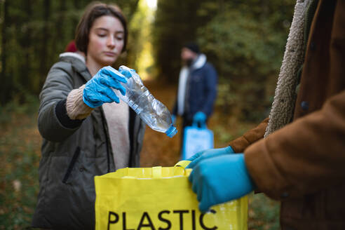 A diverse group of volunteers cleaning up forest from waste, community service concept. - HPIF06973