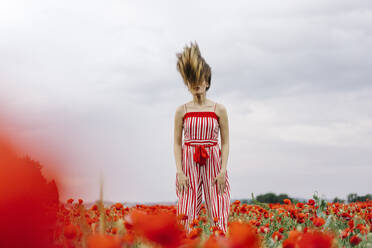Young woman tossing hair at poppy field - JJF00319