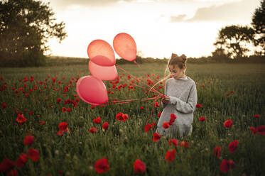 Mädchen mit roten Luftballons im Mohnfeld stehend - ALKF00133