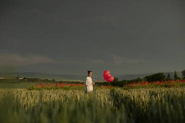 Mädchen mit Luftballons auf einer grünen Wiese bei Sonnenuntergang - ALKF00146