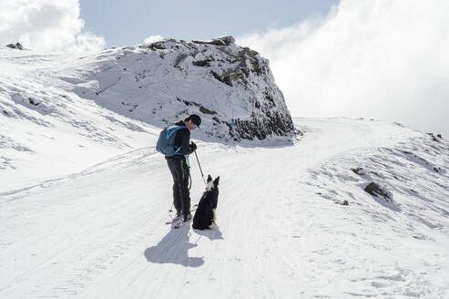 Mann stehend neben Hund an sonnigem Tag - PGF01470